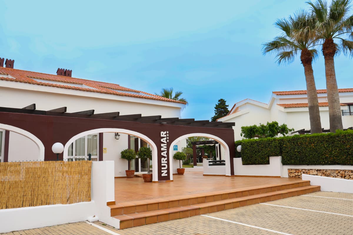 Entrada principal con cartel del Hotel Nuramar en Menorca