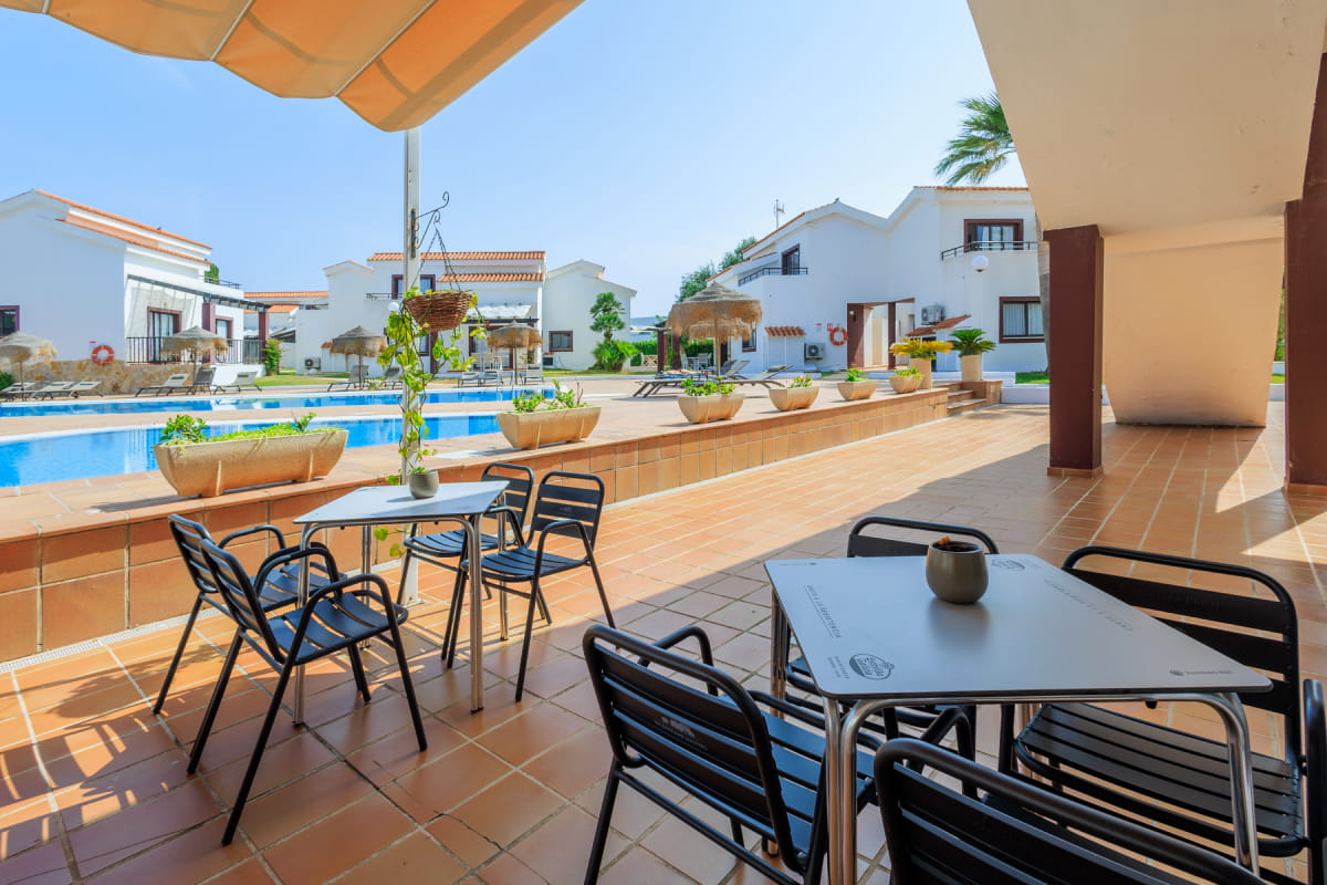 Bar con terraza y mesas frente a la piscina