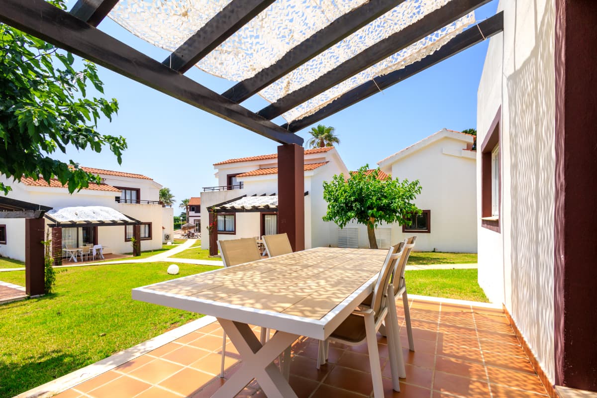 Terraza con mesa bajo pérgola en jardín 