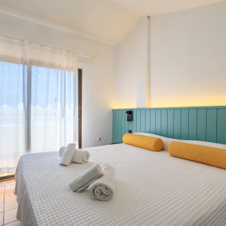 Dormitorio luminoso con cama doble y cabecero verde