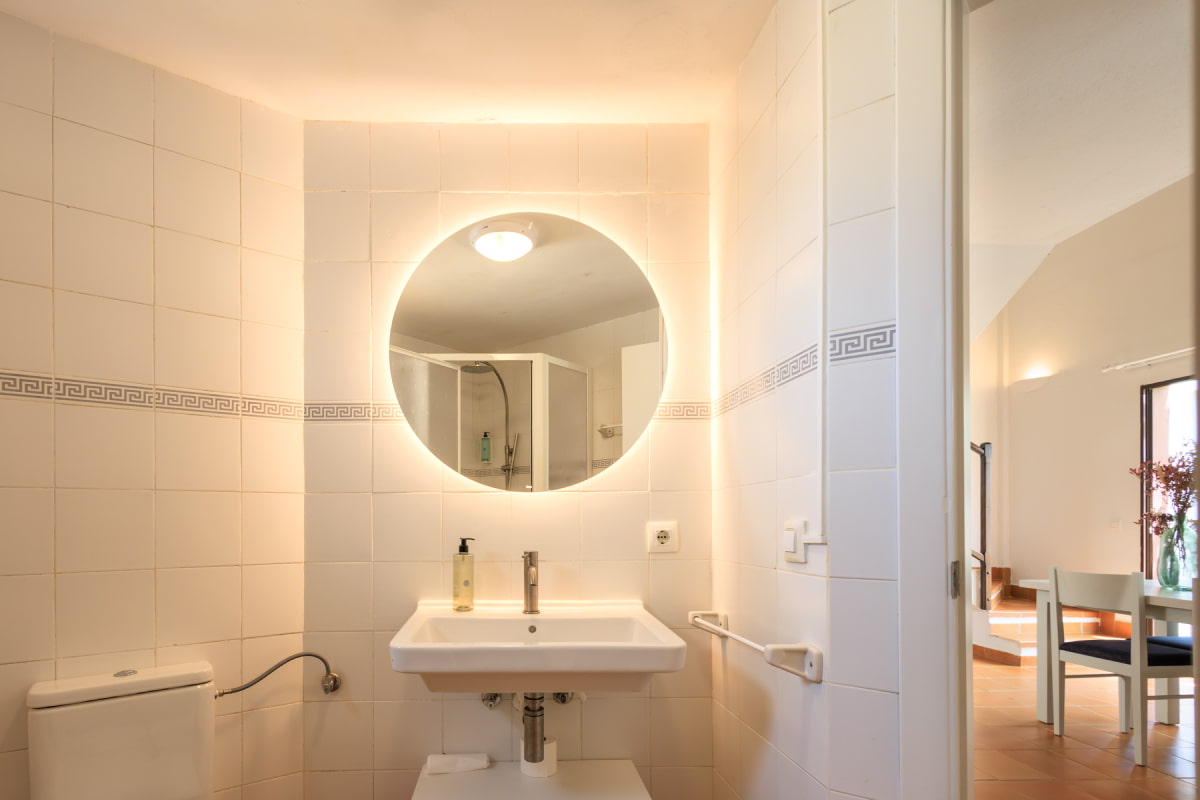 Baño moderno con espejo redondo y ducha
