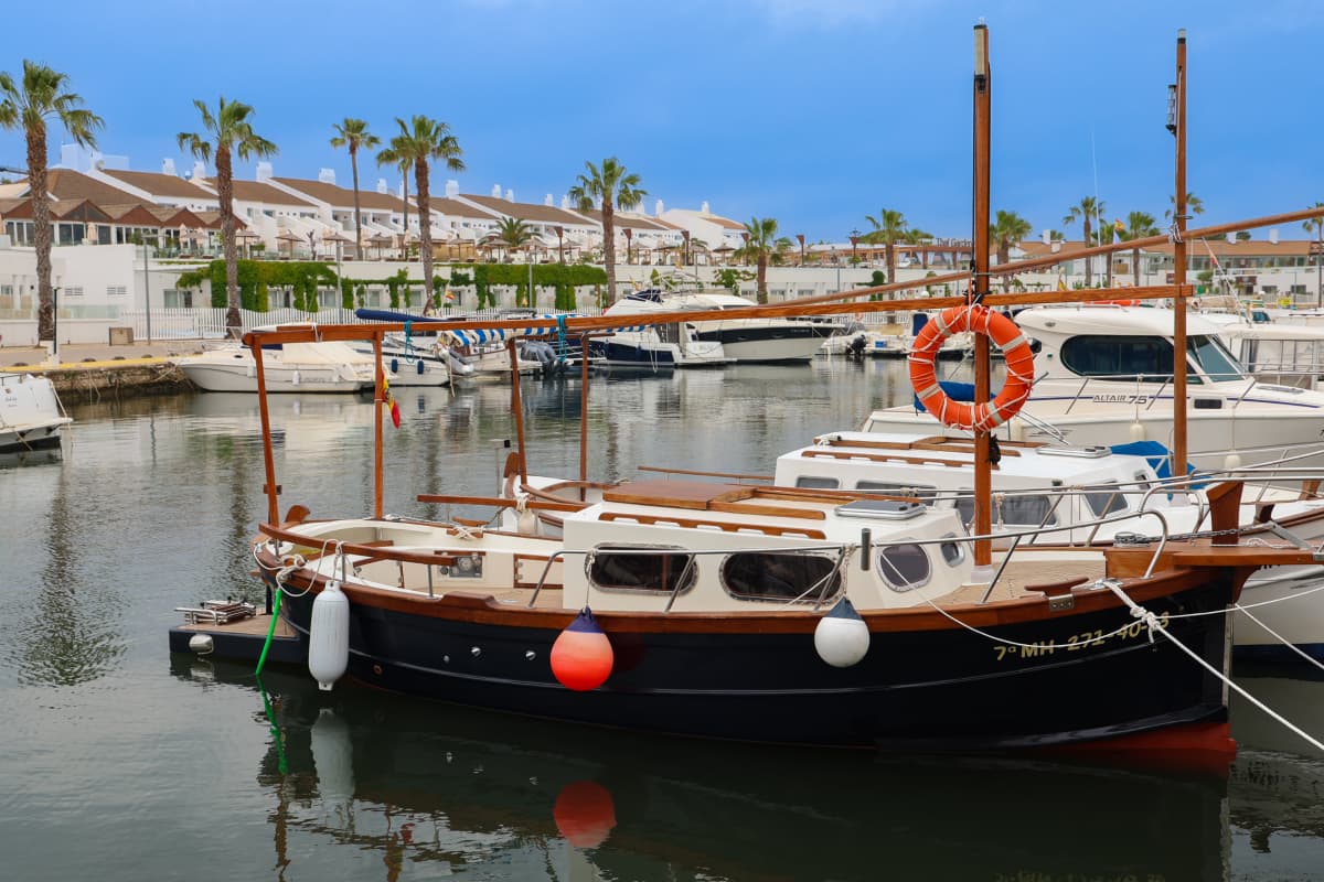 Barca tradicional menorquina amarrada en puerto de Cala en Bosch Menorca