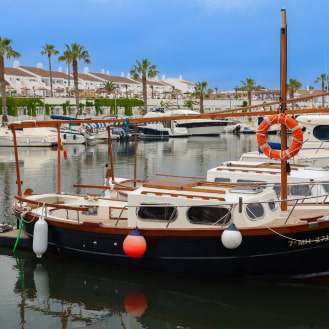 Barca tradicional menorquina amarrada en puerto de Cala en Bosch Menorca