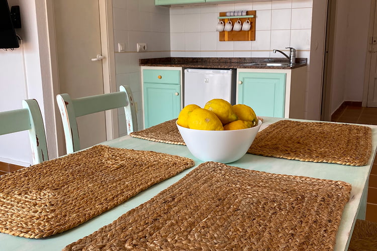 Detalle de la mesa del comedor, con manteles individuales de mimbre