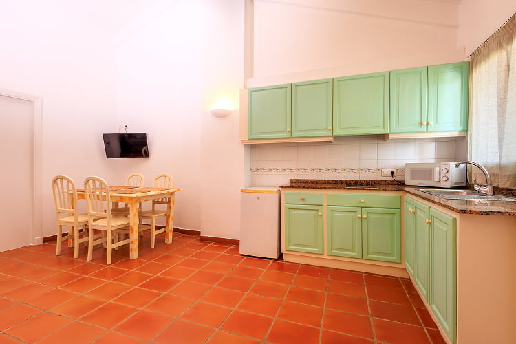 Spacious kitchen in sea water colour with dining table and TV