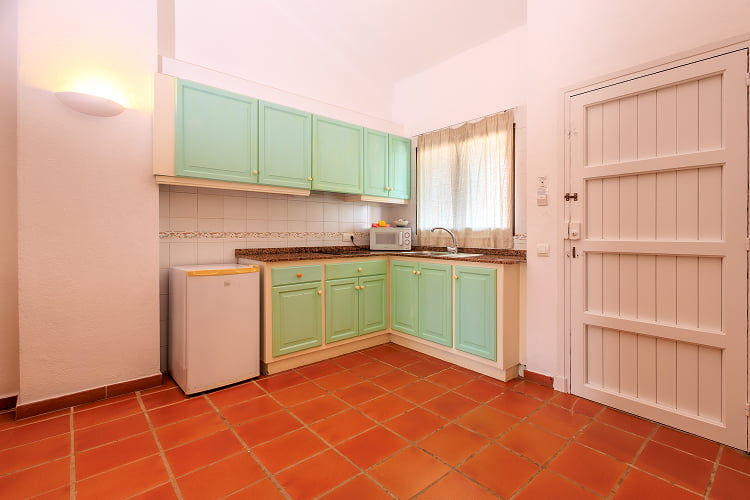 Spacious kitchen in sea water colour with dining table and TV