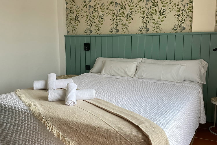 Habitación con cama King Size en tonos turquesa, arena y blanco