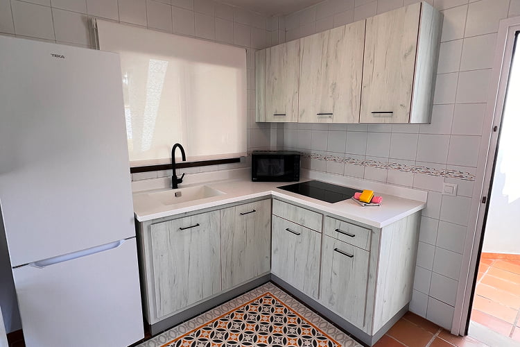 Cocina equipada con nevera, microonda y fogones