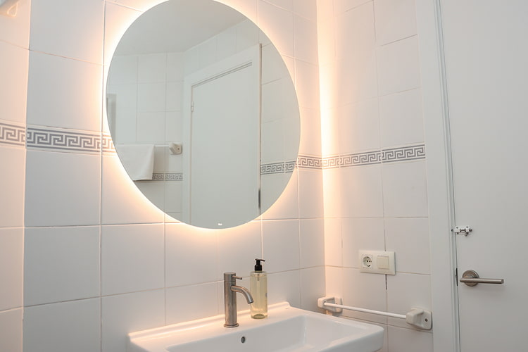 Baño con un seño y espejo con luz cálida