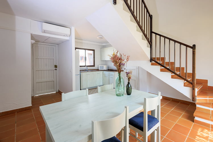 Dining table with kitchen open to the living room at the back